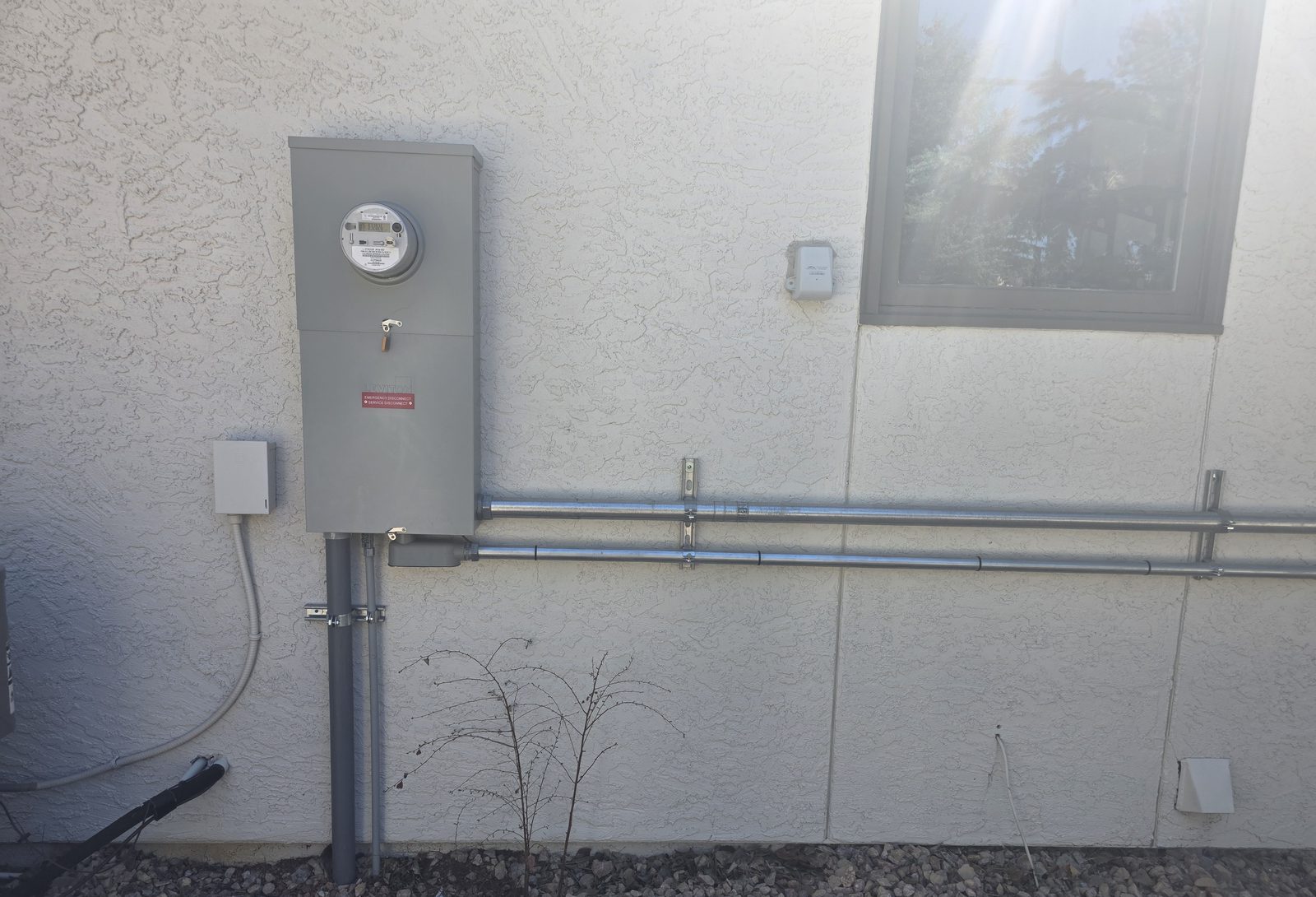 New electrical service panel and meter installed on exterior wall